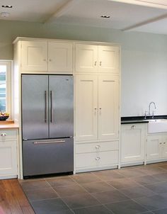 a large kitchen with white cabinets and stainless steel refrigerator freezer next to an island