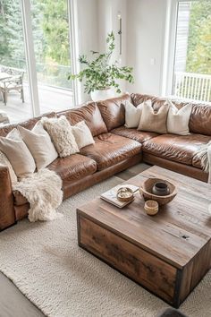 a living room with brown leather couches and pillows on top of the rugs