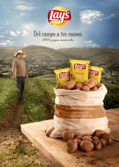 a man standing next to a bag full of potatoes on top of a wooden table