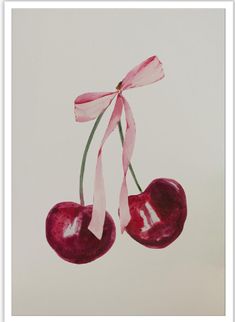 two cherries hanging from a pink ribbon