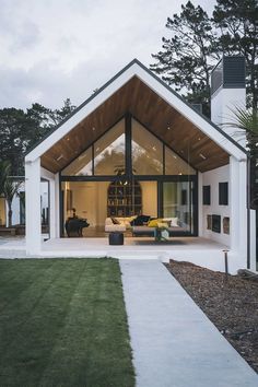 a white house with glass walls and wooden roof