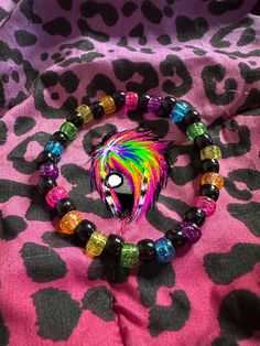 a bracelet with colorful beads and a black beaded animal head on top of it