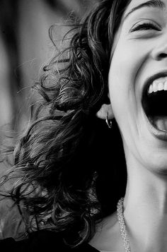 a close up of a person laughing with her mouth open