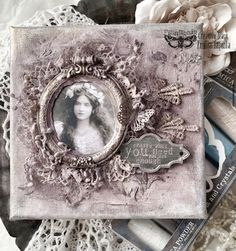 an altered photo is displayed on a doily next to some crochet and lace