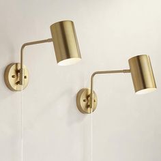 two gold wall lights on a white wall with one light turned off and the other turned off