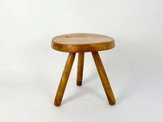 a small wooden stool sitting on top of a white floor