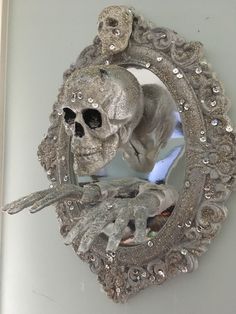 there is a mirror with a skull and skeleton in the frame on it's side