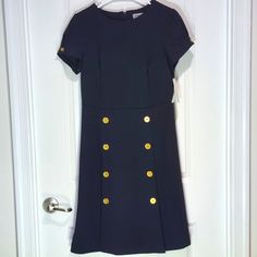 Brand: Shelby And Palmer Item Type/Name: Mini Dress Size: 12 Color: Dark Navy Blue Condition: Great Condition Material: 96% Polyester, 4% Spandex Features: Golden Button Accents, Two Slits Up The Front Care Instructions: Wash In Cold Water And Tumble Dry On Low Keywords: Nautical, Formal, Nature, Preppy, Geek, Business Casual, Office, Church, Coastal Grandma, Beach, Sailing, Classic Thank You For Checking Out My Clothes! Please Leave A Comment If You Have Any Inquiries! Fitted Navy Dress With Buttons, Navy Midi-length Dress With Buttons, Elegant Navy Midi Dress With Buttons, Navy Formal Dress With Button Closure, Formal Navy Dress With Button Closure, Classic Navy Dress With Button Closure, Navy Short Sleeve Dress With Buttons, Navy Short Sleeve Button Dress, Classic Navy Dress With Buttons