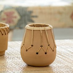 two small vases sitting on top of a wooden table next to each other,