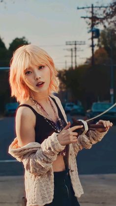 a woman with short blonde hair is standing in the street