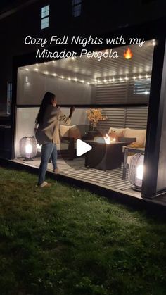 a woman standing in front of a house at night