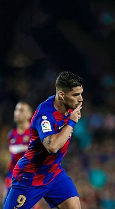 a soccer player is running with the ball in his hand as he looks down at him