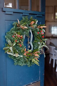 a blue door with a wreath hanging on it