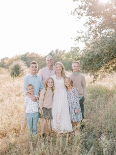 a family poses for a photo in the tall grass