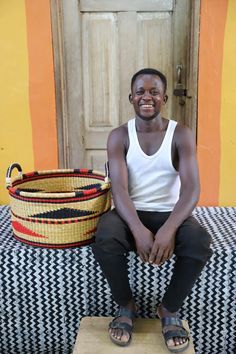 a man sitting on top of a table next to a basket