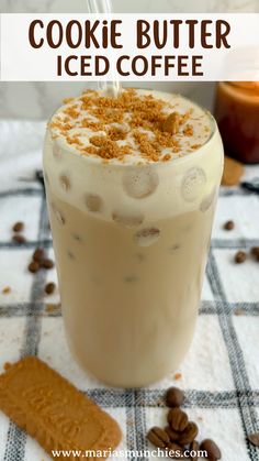 a glass filled with iced coffee and topped with cinnamon sprinkles on a checkered table cloth