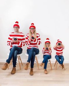 four people in matching red and white striped sweaters sitting on chairs, one holding a camera