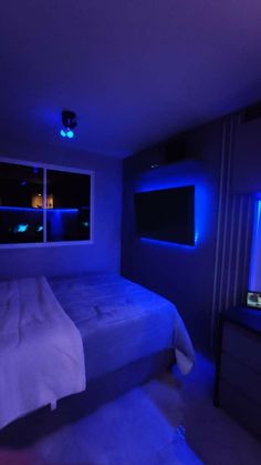 a bed in a room with blue lights on the walls and windows above it,