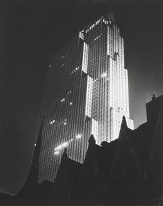 a very tall building lit up in the dark night sky with lights on it's sides