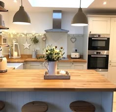 a kitchen with three stools and a center island in the middle of the room