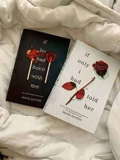 two books laying on top of a bed next to each other in the middle of white sheets