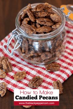 a glass jar filled with candied pecans on top of a red and white checkered table cloth