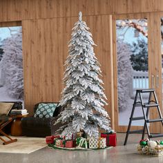 a white christmas tree with presents under it