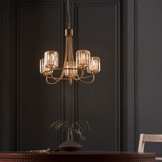 a chandelier hanging from the ceiling in a room with dark walls and chairs