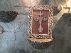 a cross is hanging on the wall in a room with stone walls and flooring