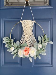 a blue door with a white and pink wreath hanging on it