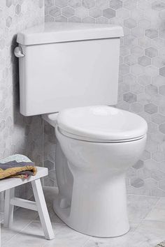 a white toilet sitting next to a wooden step stool