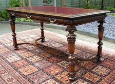 an old wooden table sitting on top of a rug