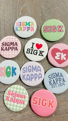 six buttons with different designs on them sitting on a wooden table next to each other