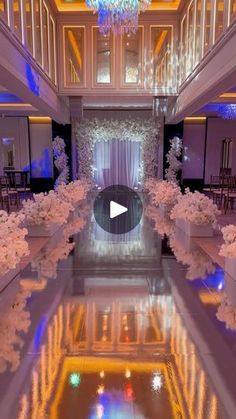 the inside of a building with flowers and chandeliers