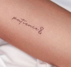 a person with a tattoo on their arm that reads,'patient'in cursive writing