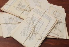 several old books tied together with twine and string on top of each other, sitting on a wooden table