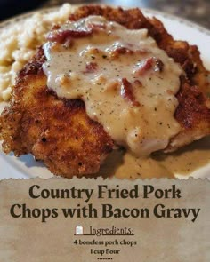 a plate with some fried pork chops covered in gravy