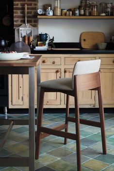 a kitchen with wooden cabinets and counter tops, two stools in front of the counter