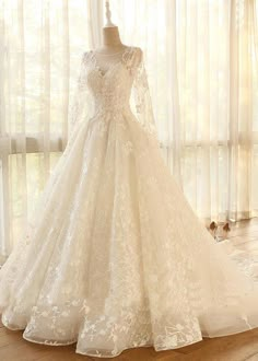 a wedding dress on display in front of a window