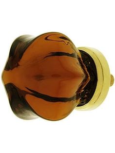 an orange glass door knob with a black and yellow design on the top, in front of a white background