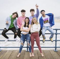 a group of young people standing on top of a pier