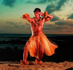 a man in an orange hula skirt standing on the beach with his hands behind his head