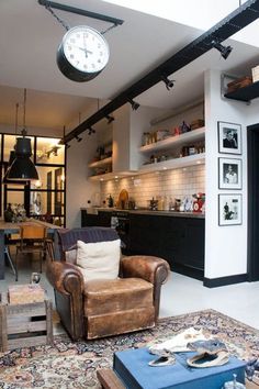 a living room filled with furniture and a clock hanging from the ceiling