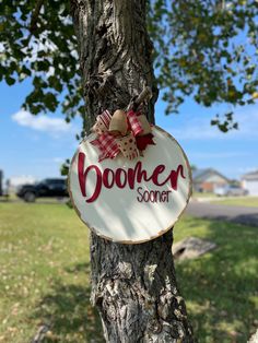 a wooden sign that says boomer sonnet hanging on a tree in the grass