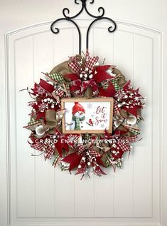 a christmas wreath hanging on the front door with a sign that says, let it snow