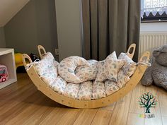 a child's swing bed in the corner of a room with stuffed animals on the floor