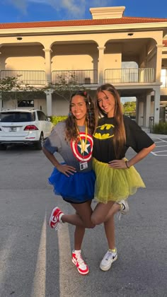 two girls are standing in the middle of a parking lot with their arms around each other