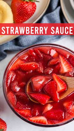 strawberry sauce in a glass bowl with spoon and sliced strawberries next to it on a white surface