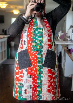 a woman in an apron taking a photo with her camera