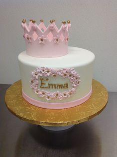 a white and pink cake with a crown on top